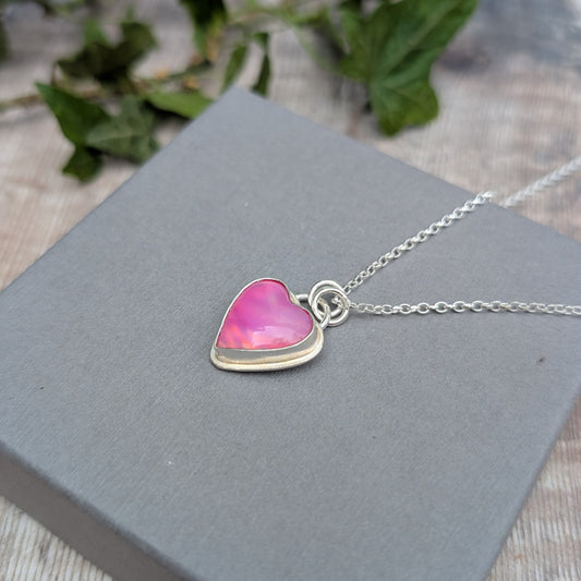 Close-up of a Pink Aurora Opal Heart Necklace handmade from recycled Sterling Silver, showing the pink heart-shaped Aurora Opal in a silver setting.