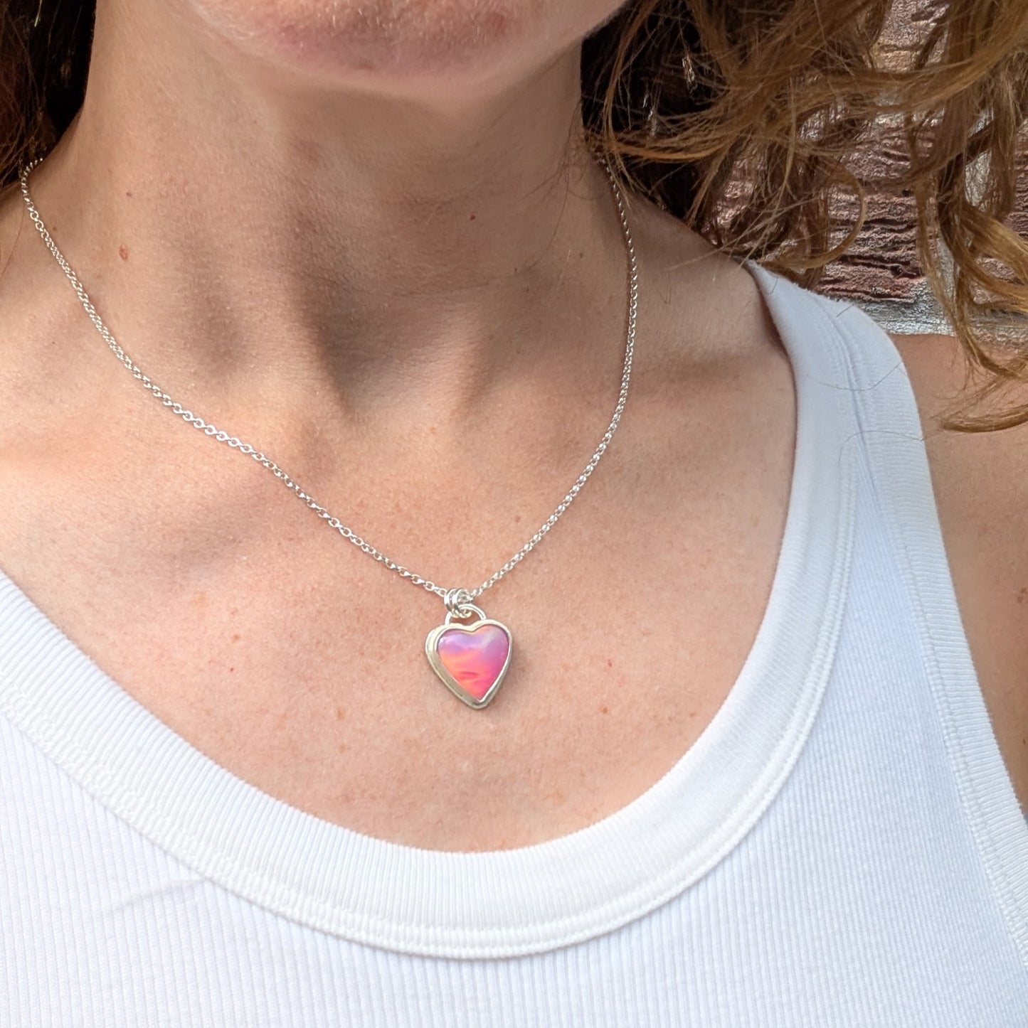 Pink Aurora Opal Heart Necklace handmade from recycled Sterling Silver worn on a chain around the neck.