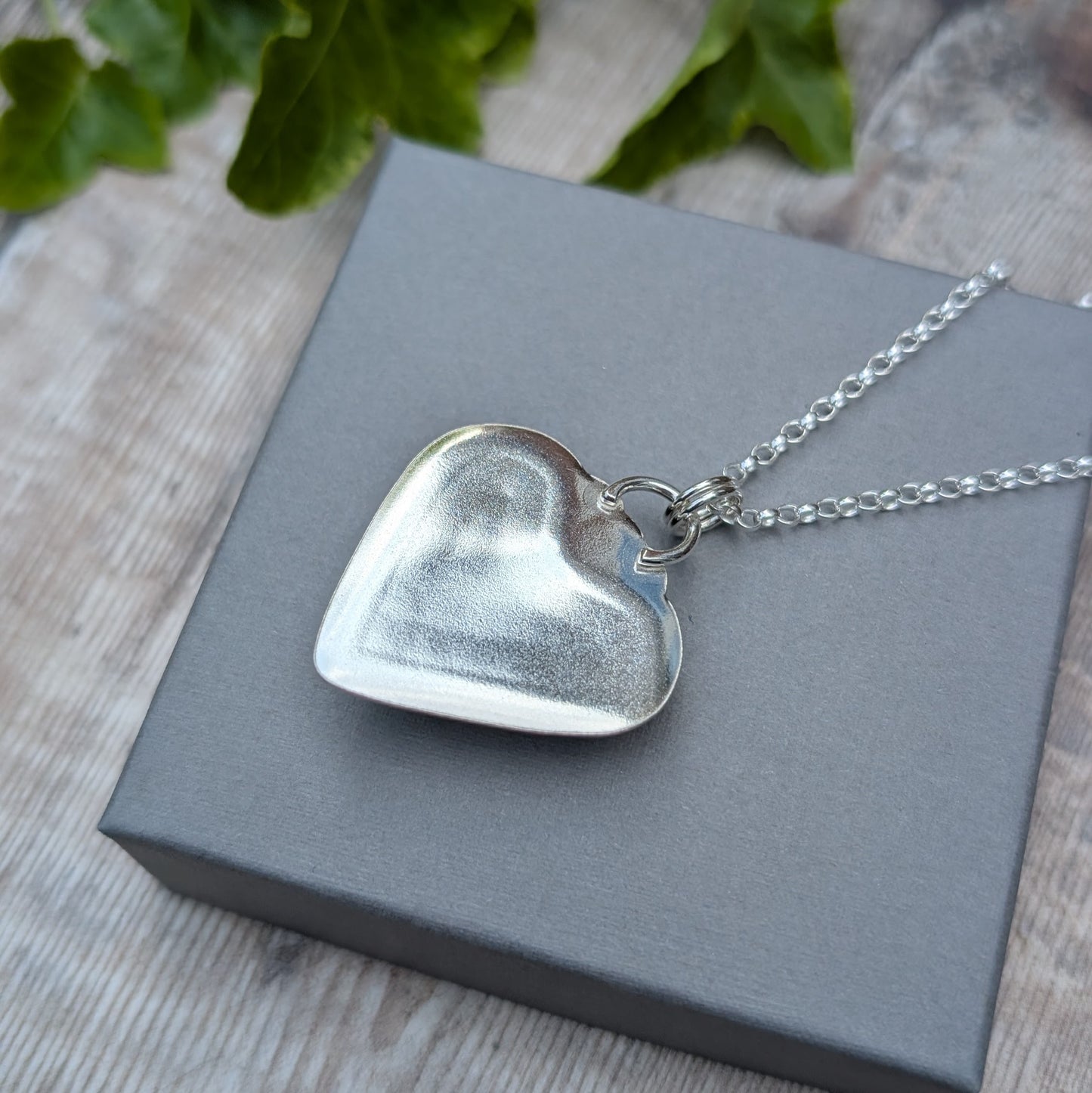 Back view of Plume Agate Heart Necklace showing smooth handmade sterling silver setting