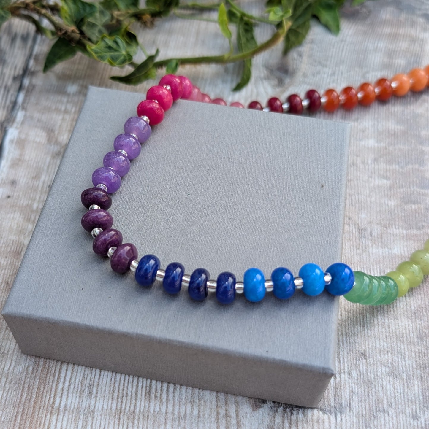Rainbow Jade Bead Necklace with colourful jade beads and recycled Sterling Silver spacers displayed on a grey jewellery box.