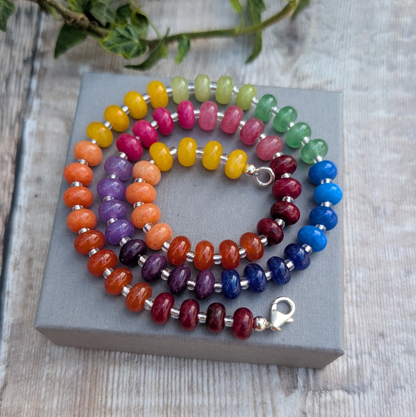 Rainbow Jade Bead Necklace coiled on a grey jewellery box, highlighting the rainbow colours of the jade beads and recycled Sterling Silver spacers.
