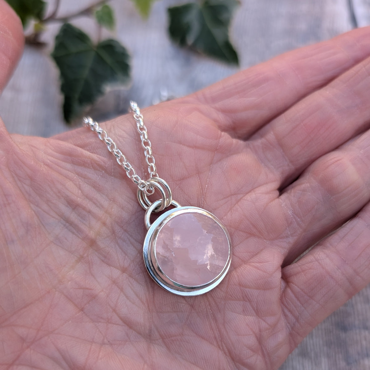 Rose Quartz Statement Gemstone Necklace resting in the palm of a hand, showing the polished recycled sterling silver setting and natural pink Rose Quartz gemstone.