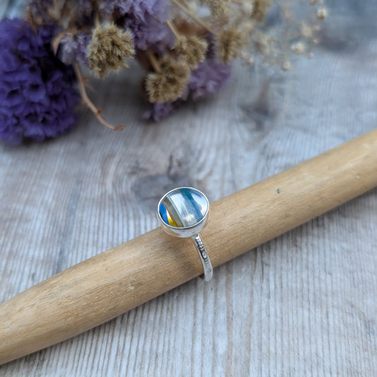 Round Surfite ring resting on a ring mandrel, with a clear view of the layered Surfite stone and silver band texture.