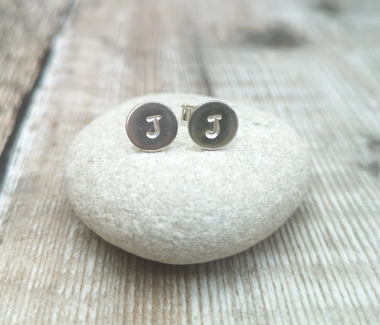 Each earring is a small Sterling Silver disc with an initial stamped in the centre. Mounted onto a silver stud wire.