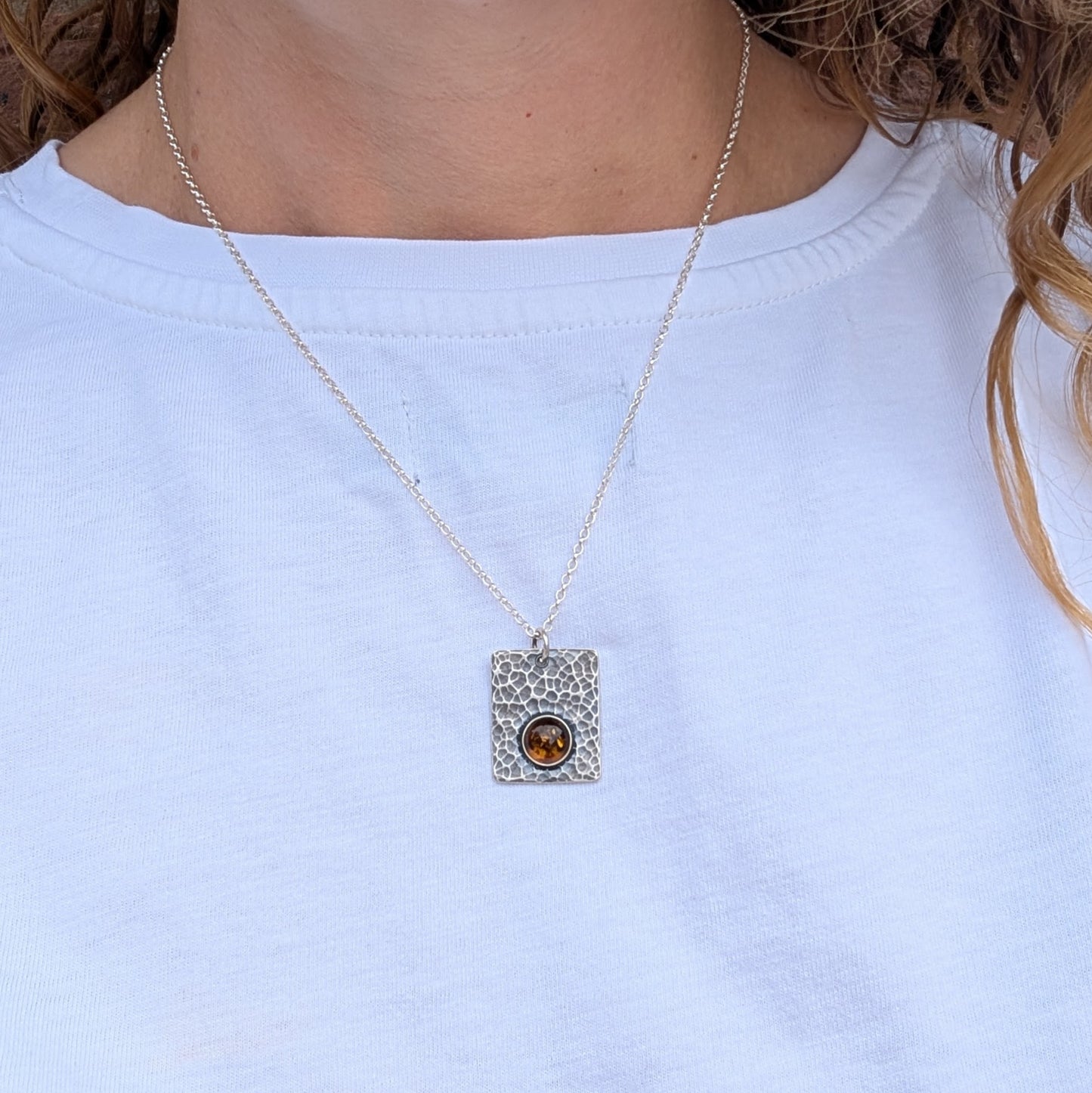 Silver Rectangle Necklace with Amber worn on a silver chain, shown against a plain white top.