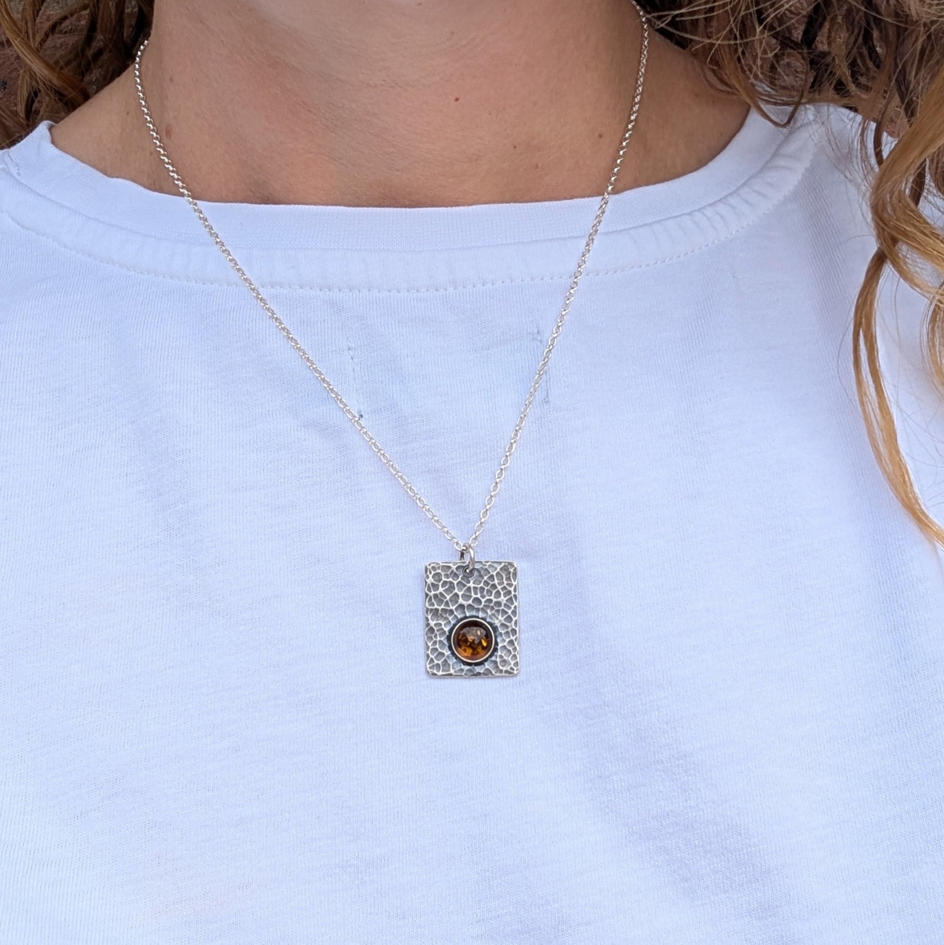 Silver Rectangle Necklace with Amber worn on a silver chain, shown against a plain white top.