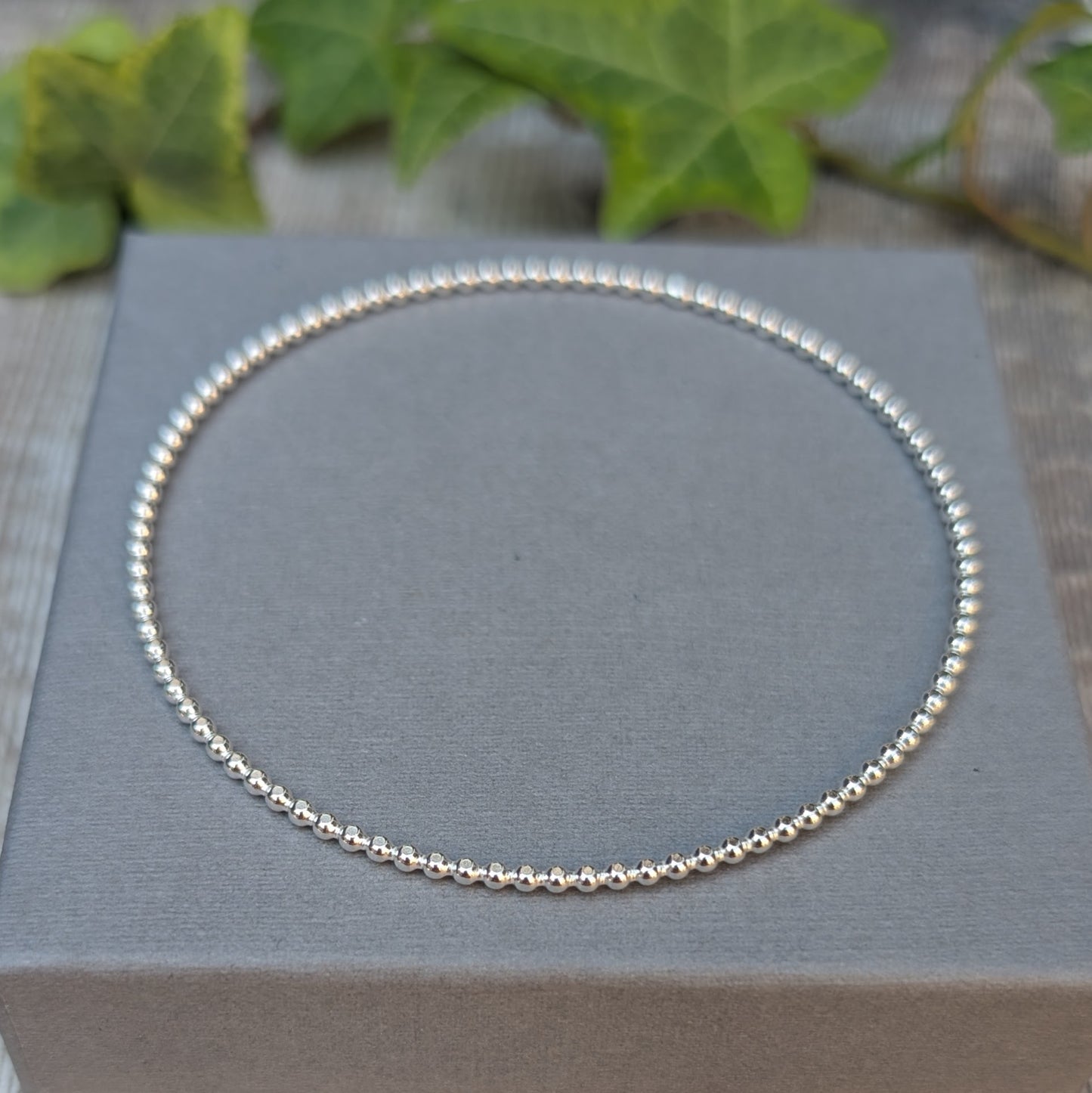 Close view of a Silver 2mm Beaded Round Bangle showing the small beaded pattern around the silver wire.