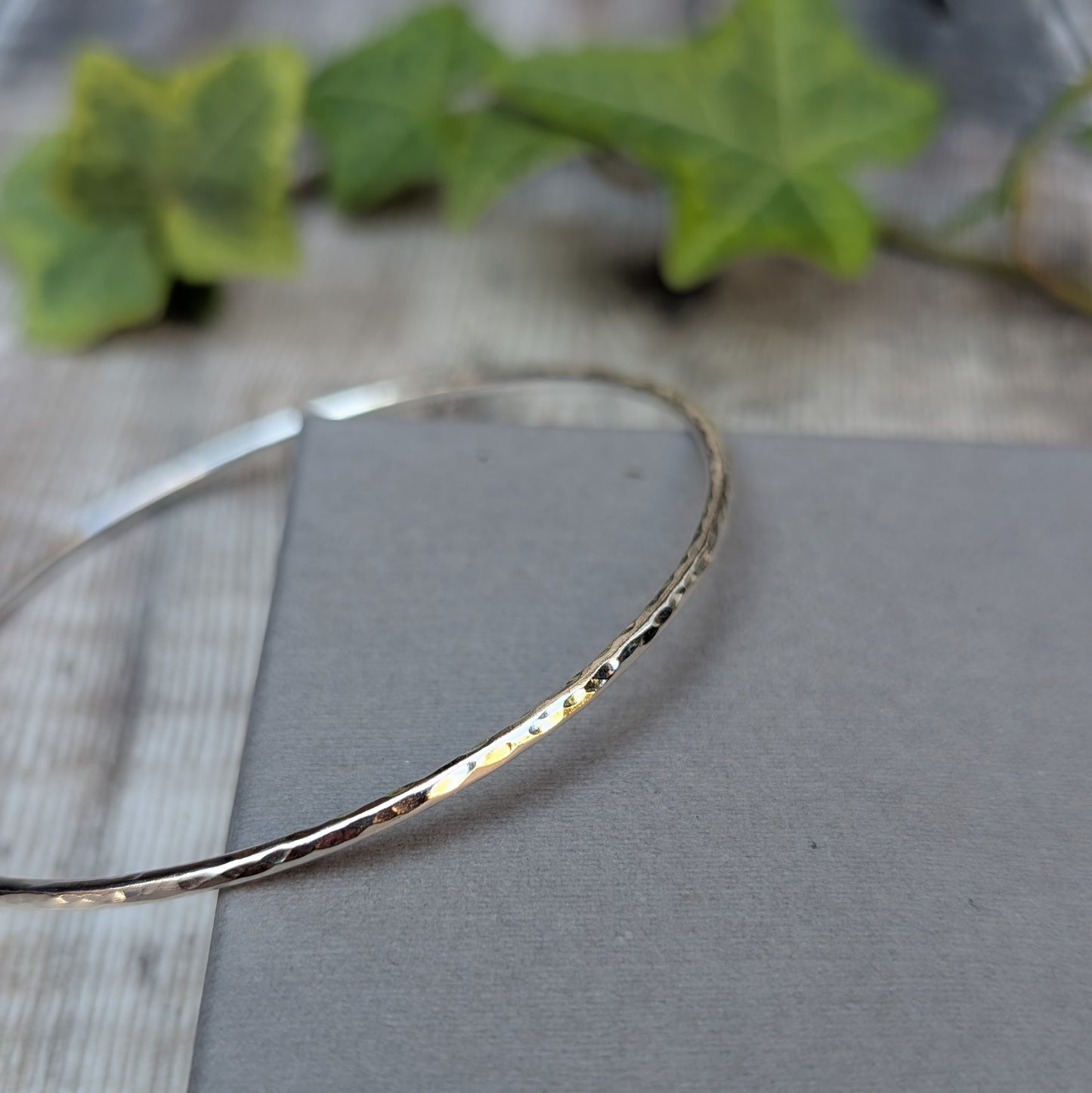 Detailed close up of a Silver 2mm Hammered Round Bangle showing the textured recycled Sterling Silver catching the light.