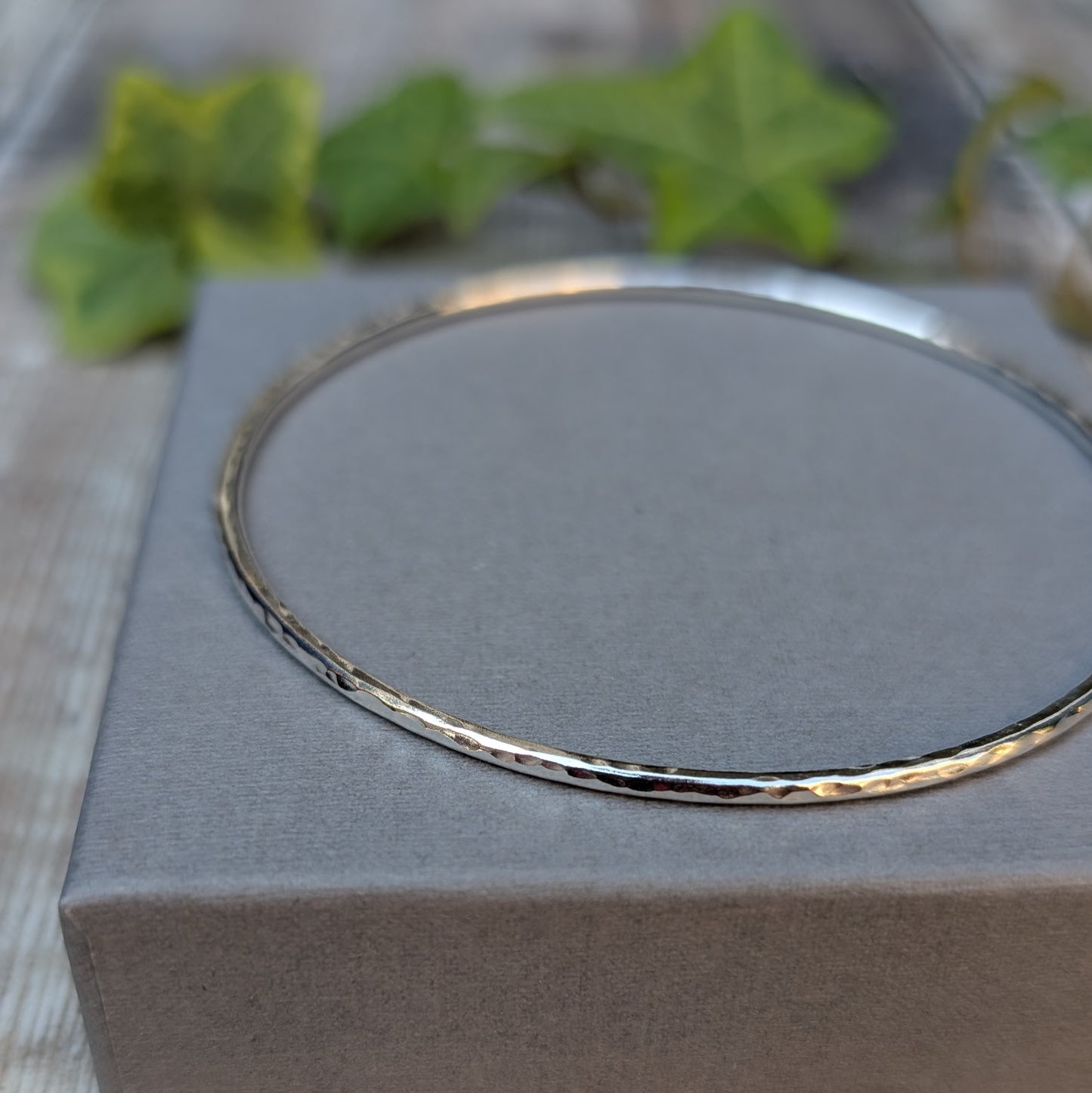 Close up of a Silver 2mm Hammered Round Bangle showing the handmade hammered texture and polished Sterling Silver surface.