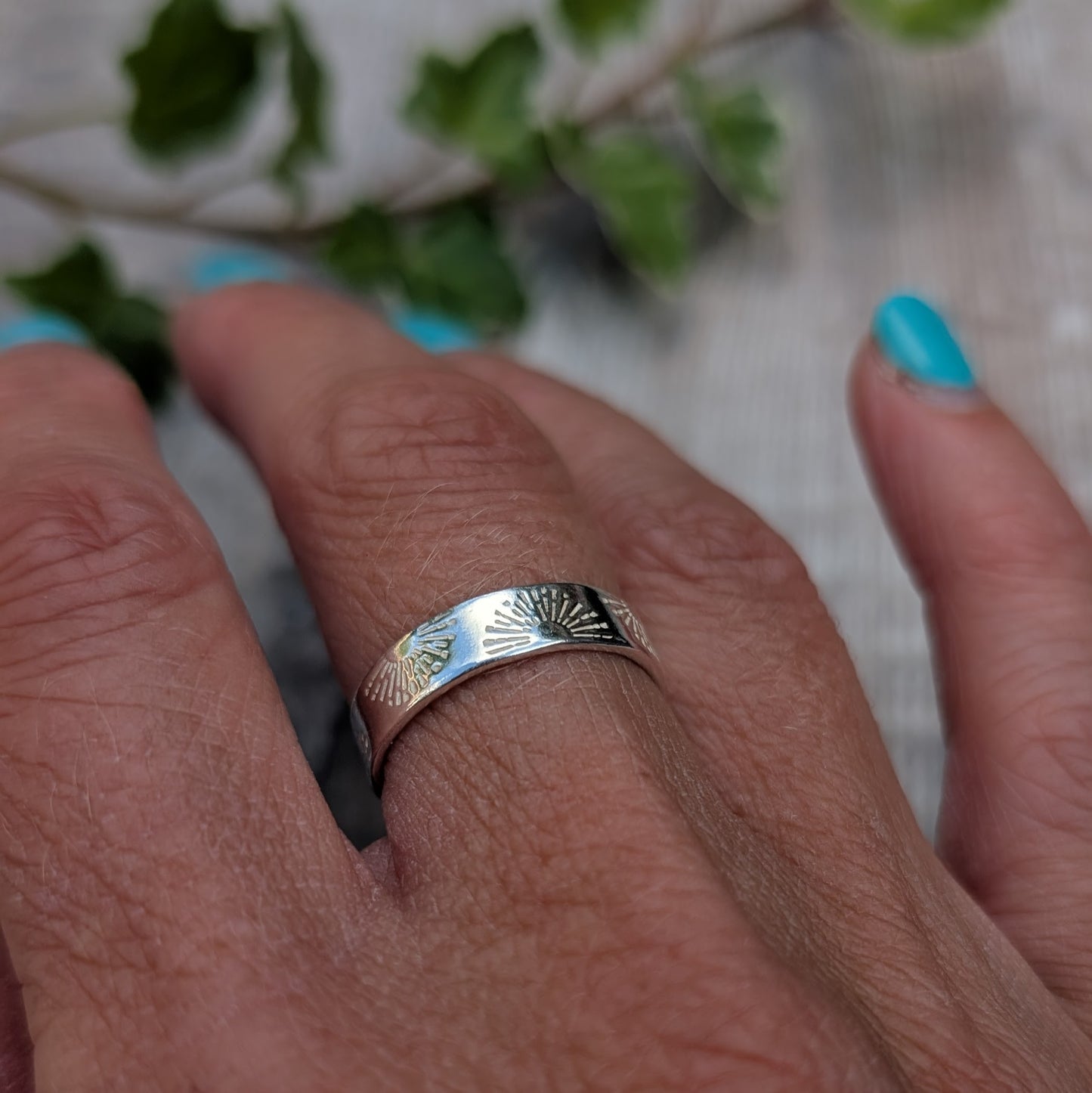 Silver 5mm Sunrise Ring handmade from recycled Sterling Silver with a hand stamped sunrise pattern, worn on a finger.
