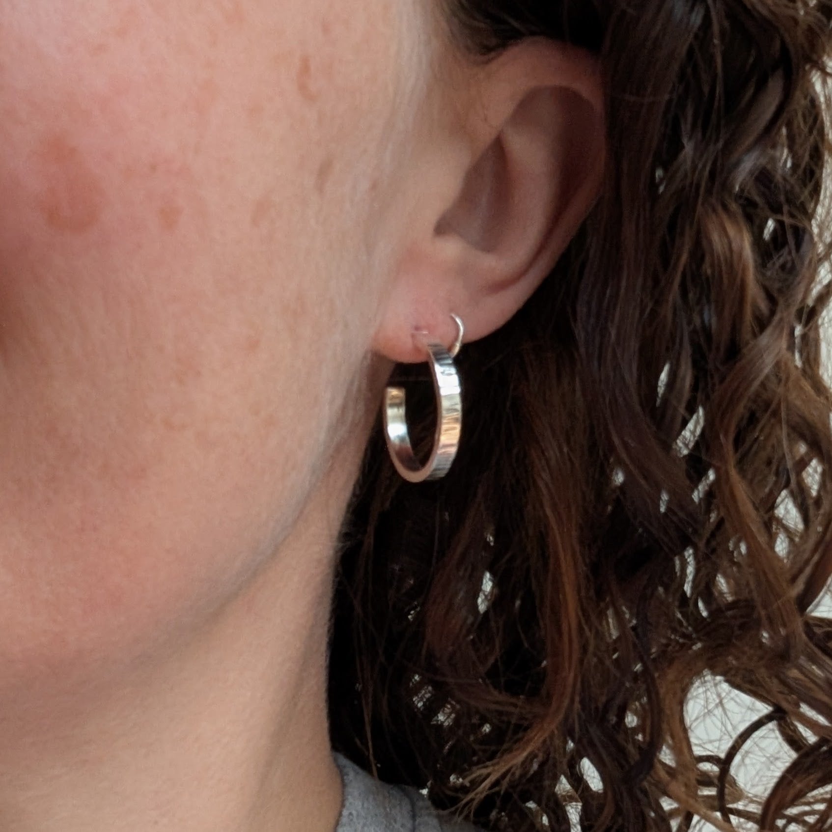 Silver Bark Textured Hoop Earrings worn on an ear, showing their comfortable stud fitting and medium-sized hoop design.