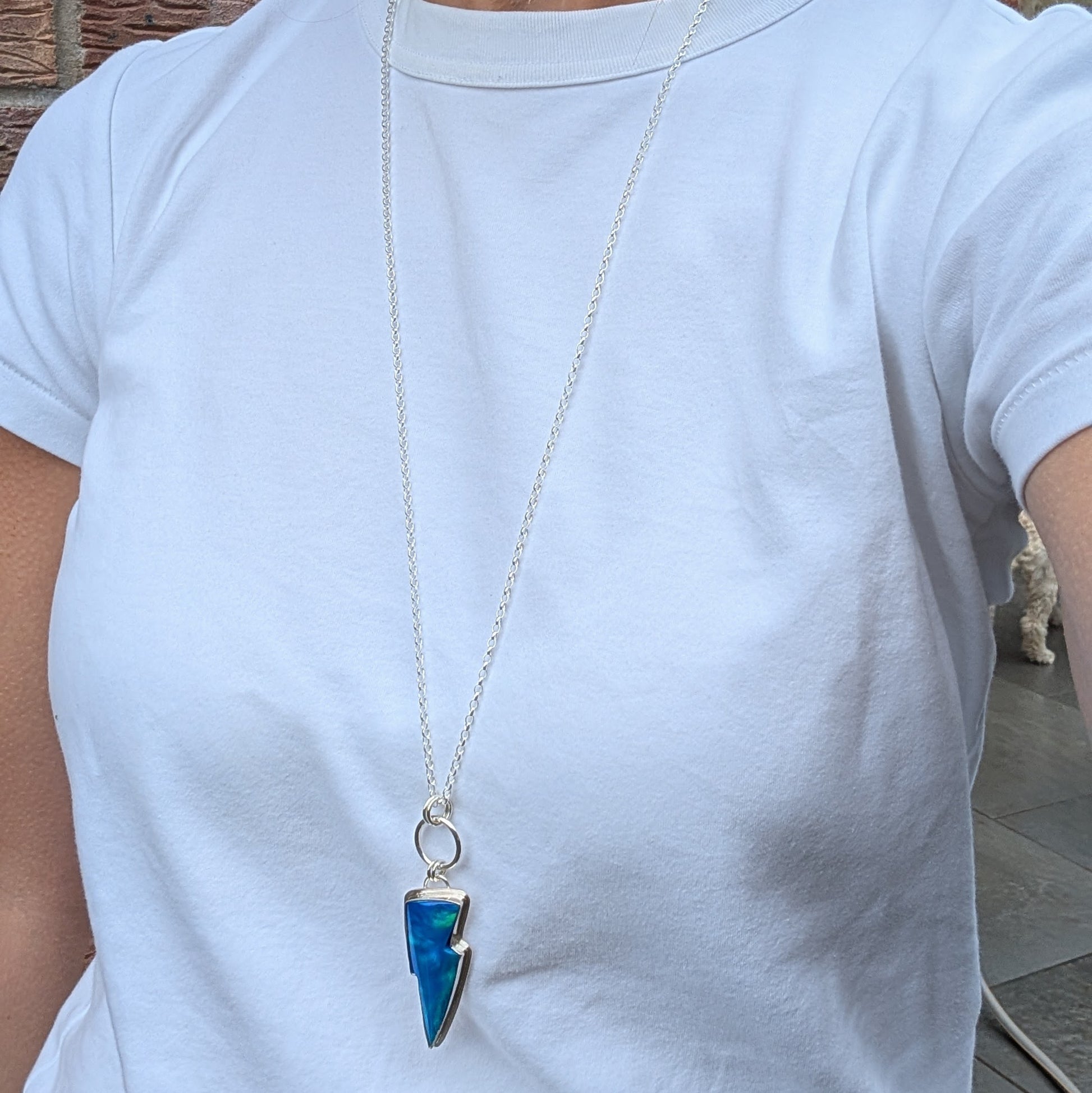 Silver Blue Aurora Opal Lightning Bolt Necklace worn on a long sterling silver chain, showing the size and fit of the necklace when worn.