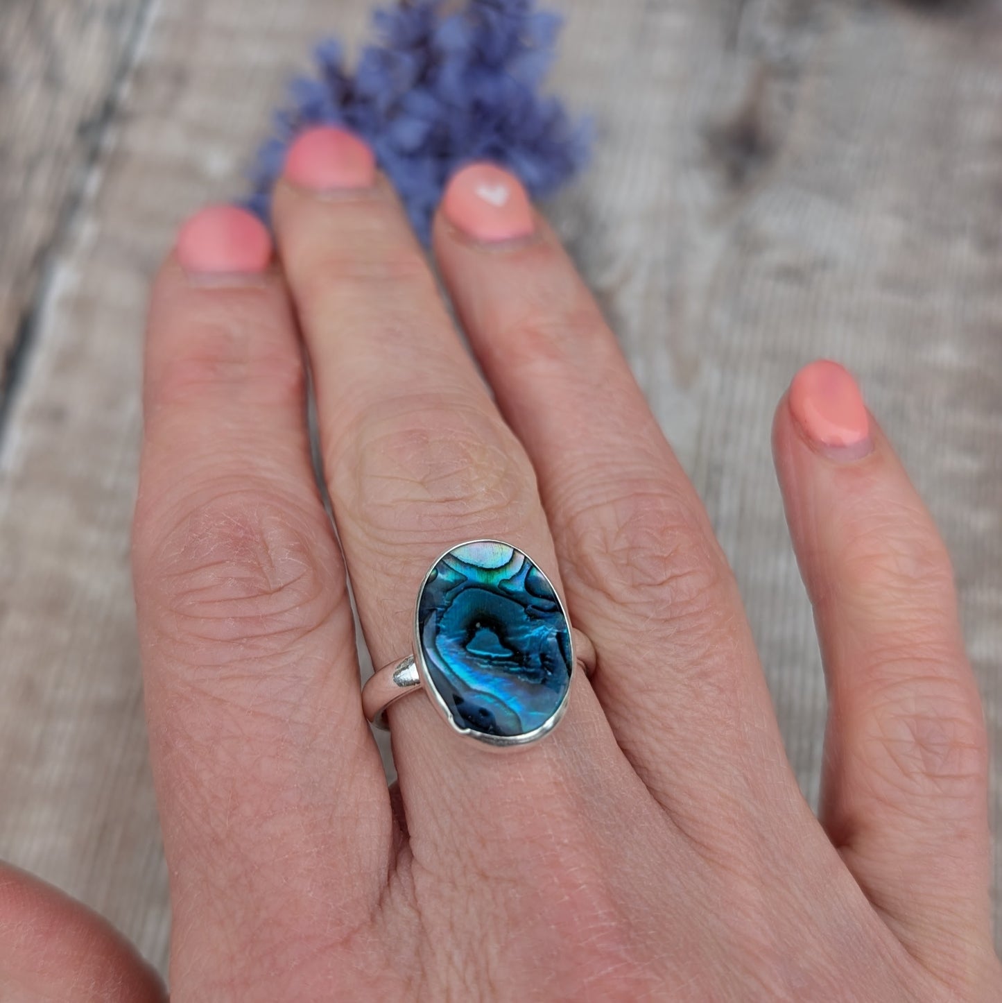 Silver Blue Paua Shell Ring worn on a hand showing the fit and scale of the recycled Sterling Silver band.