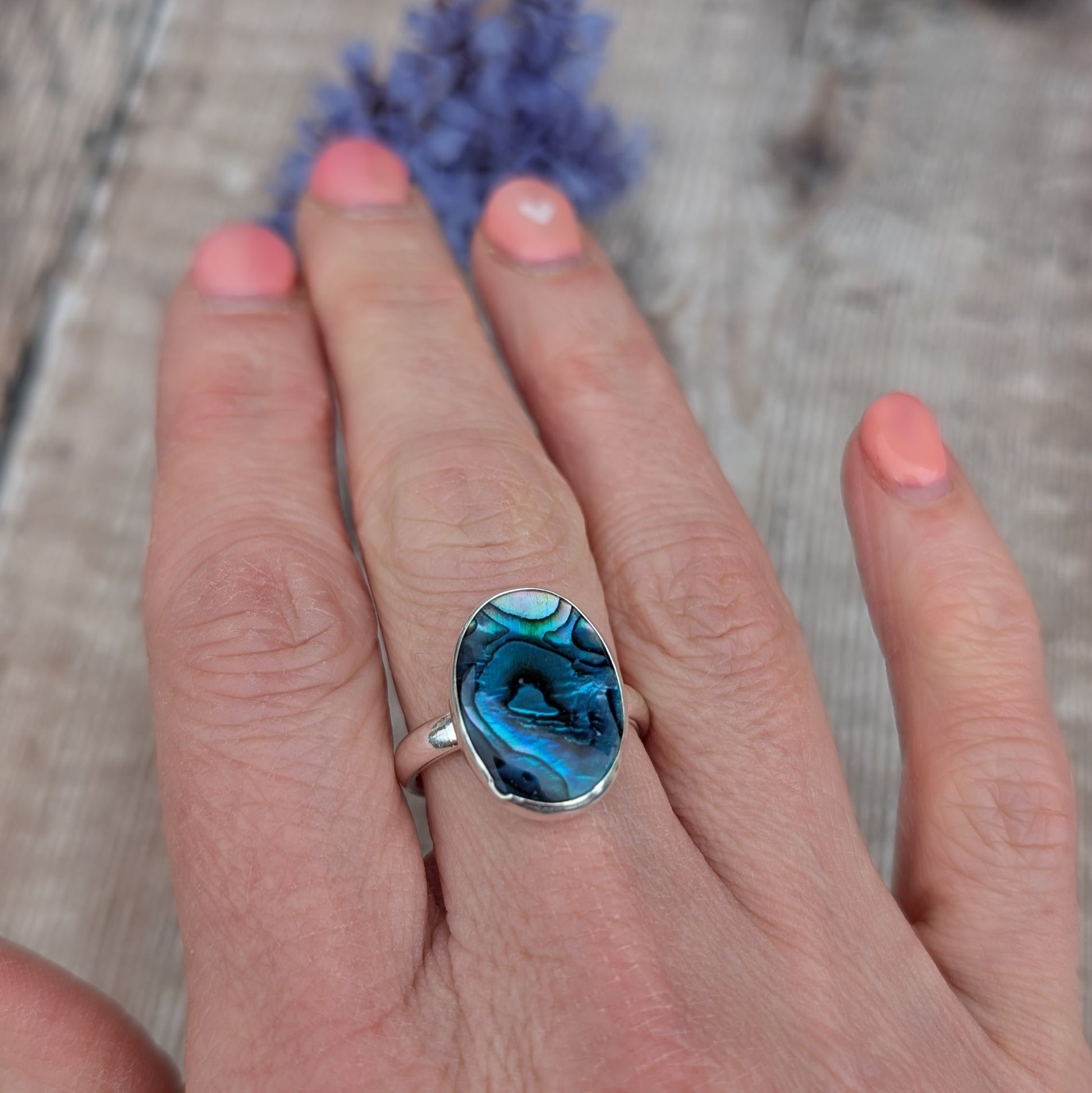 Silver Blue Paua Shell Ring worn on a hand showing the fit and scale of the recycled Sterling Silver band.