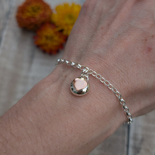 Silver Bracelet with Silver Pebble and Copper Heart Charm worn on the wrist, showing how the charm sits and moves when worn.