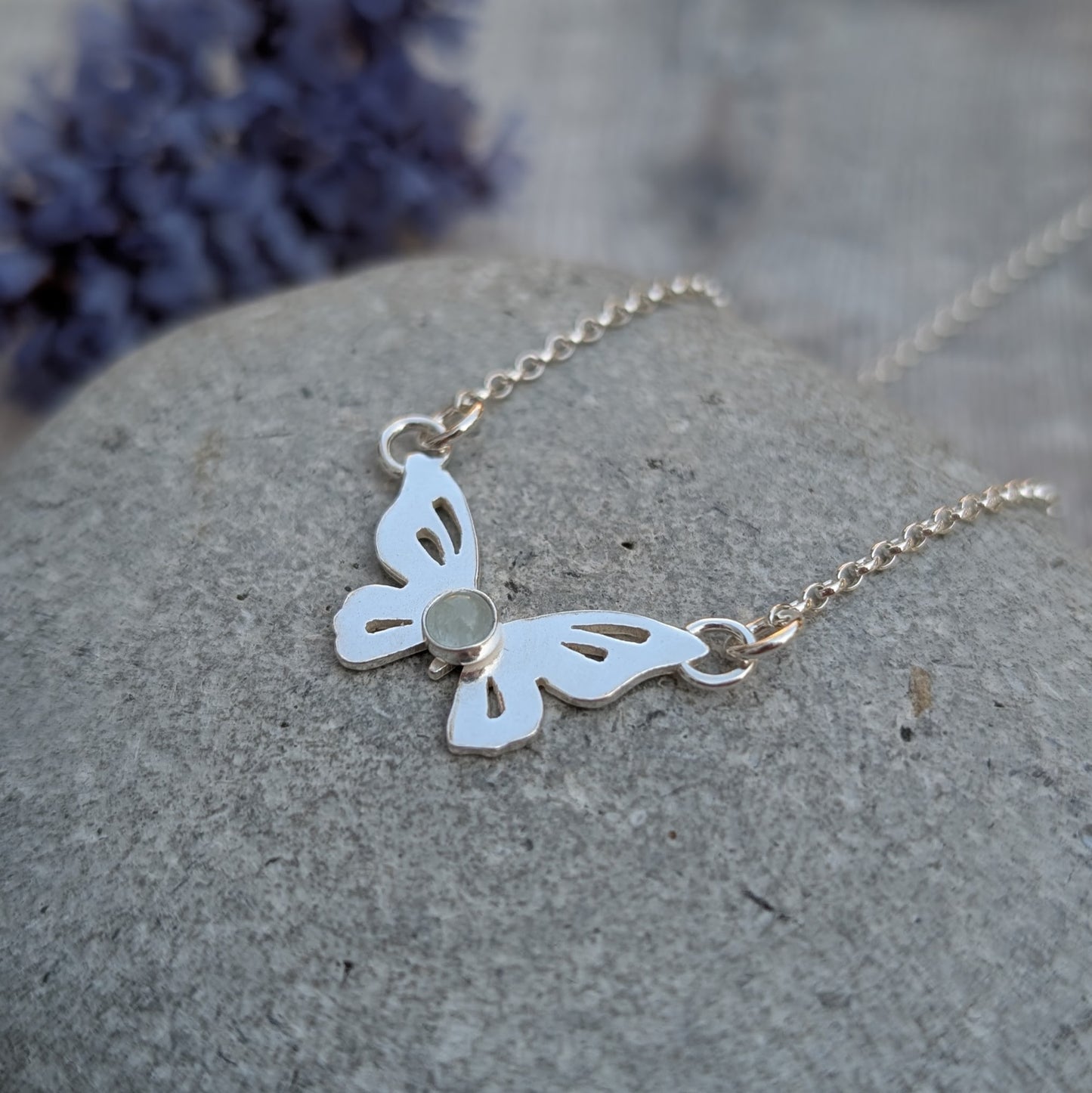 Close-up of Silver Butterfly Necklace with Aquamarine on a stone, focusing on the handmade butterfly and aquamarine detail