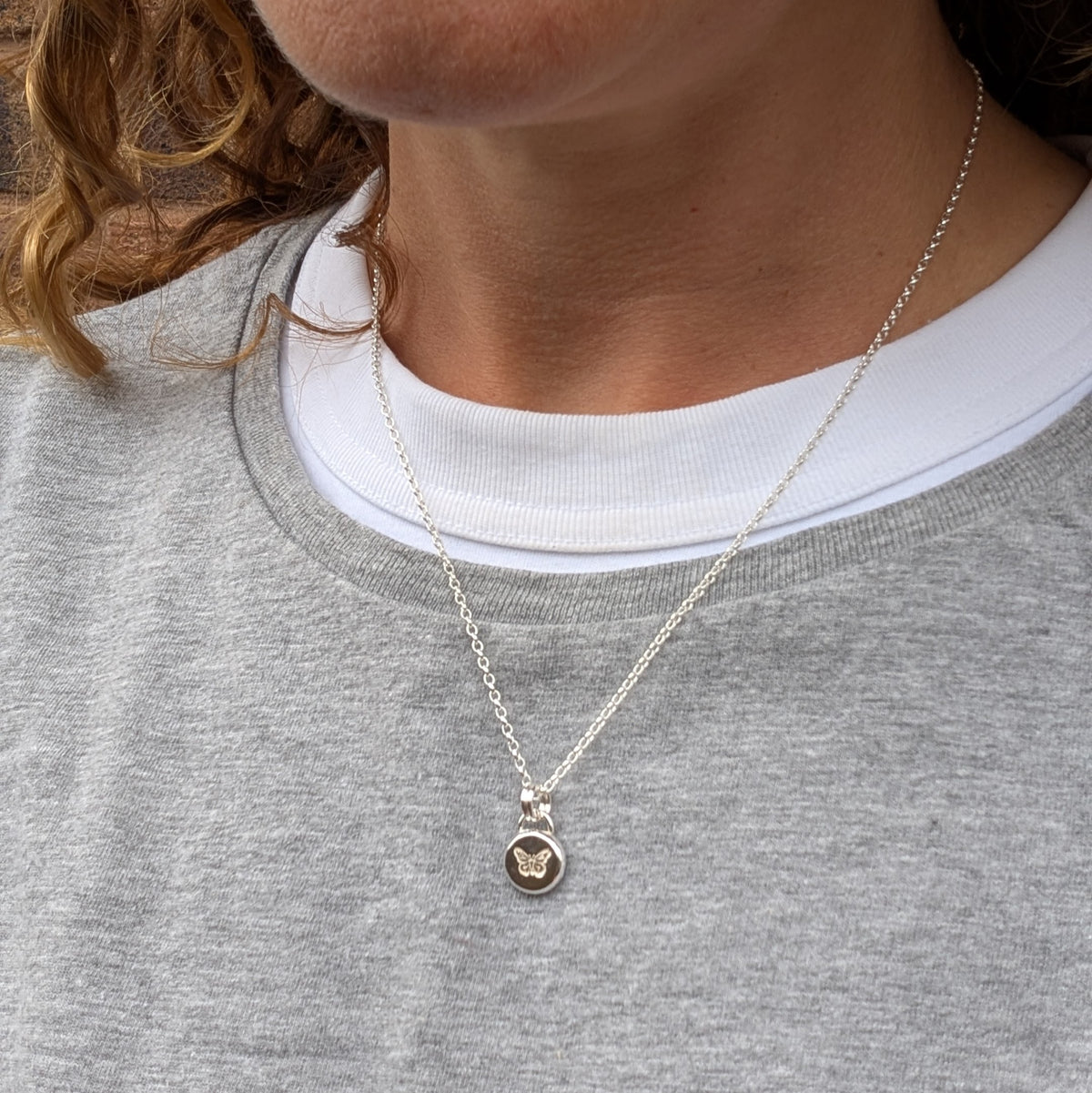Silver butterfly pebble necklace being worn, showing the size and length of the recycled Sterling Silver pendant and chain.