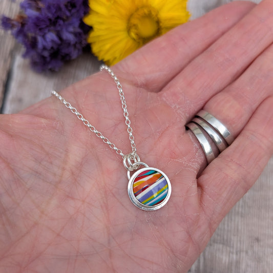 Silver Colourful Small Round Surfite Necklace shown in a hand to show size and detail