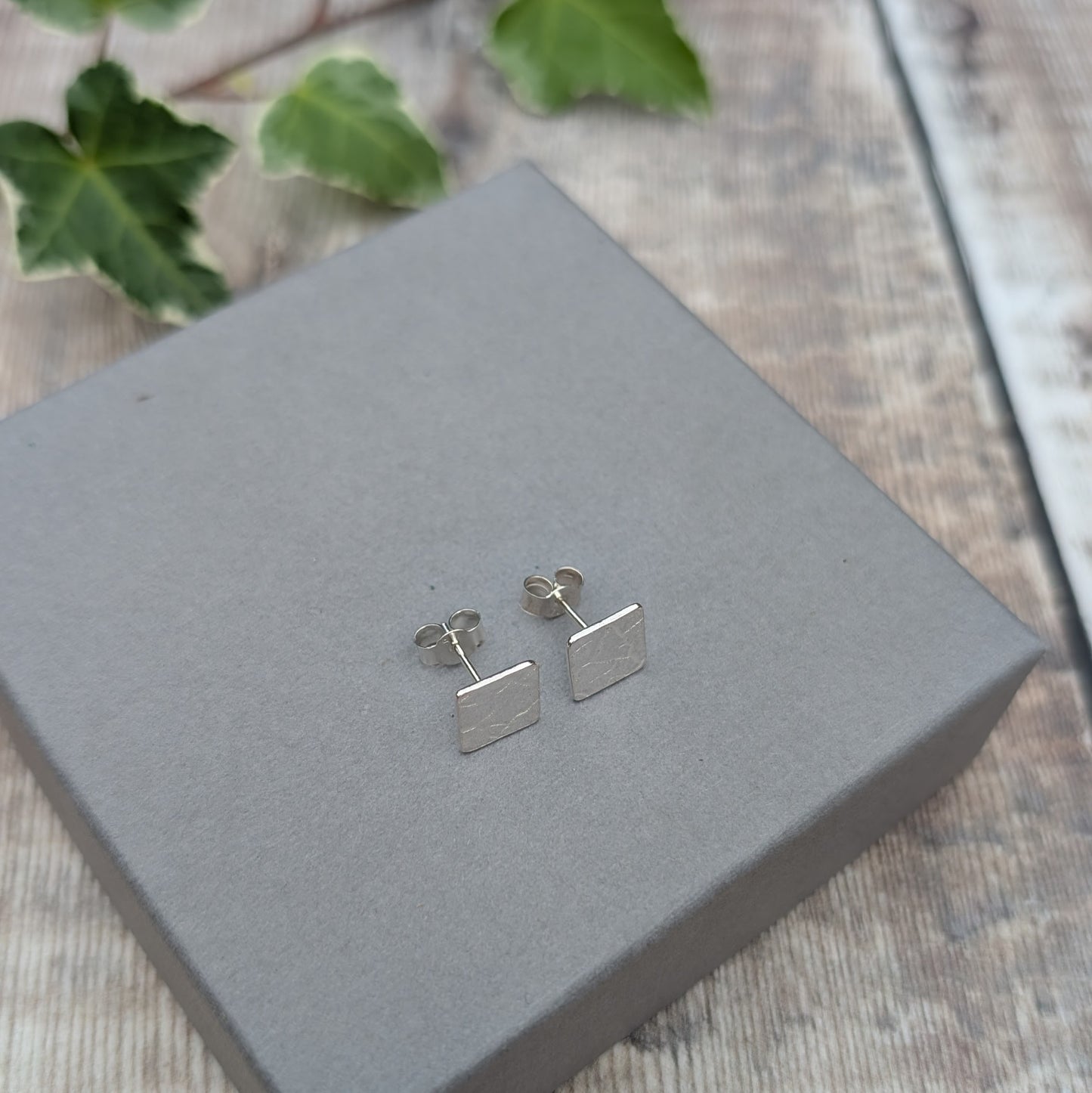 Back view of silver cracked earth pattern square stud earrings showing the Sterling Silver posts and butterfly backs.