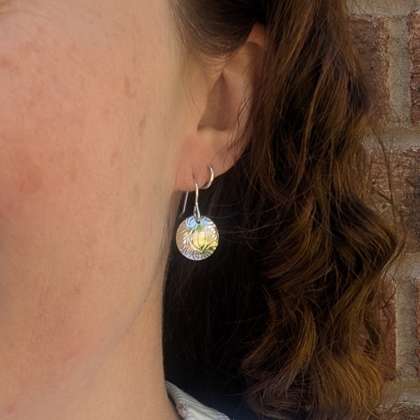 Silver Dome Disc Earrings with Leaf Pattern worn on ear, showing size and how they hang.