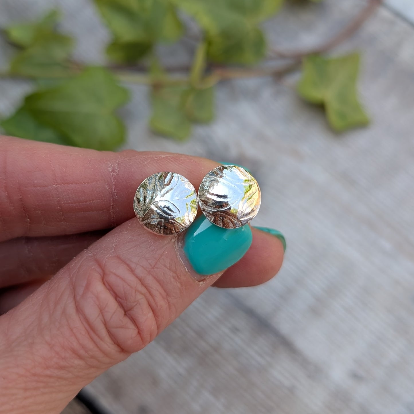 Close-up of Silver Dome Disc Stud Earrings with Leaf Pattern, highlighting the leaf texture pressed into the silver surface.