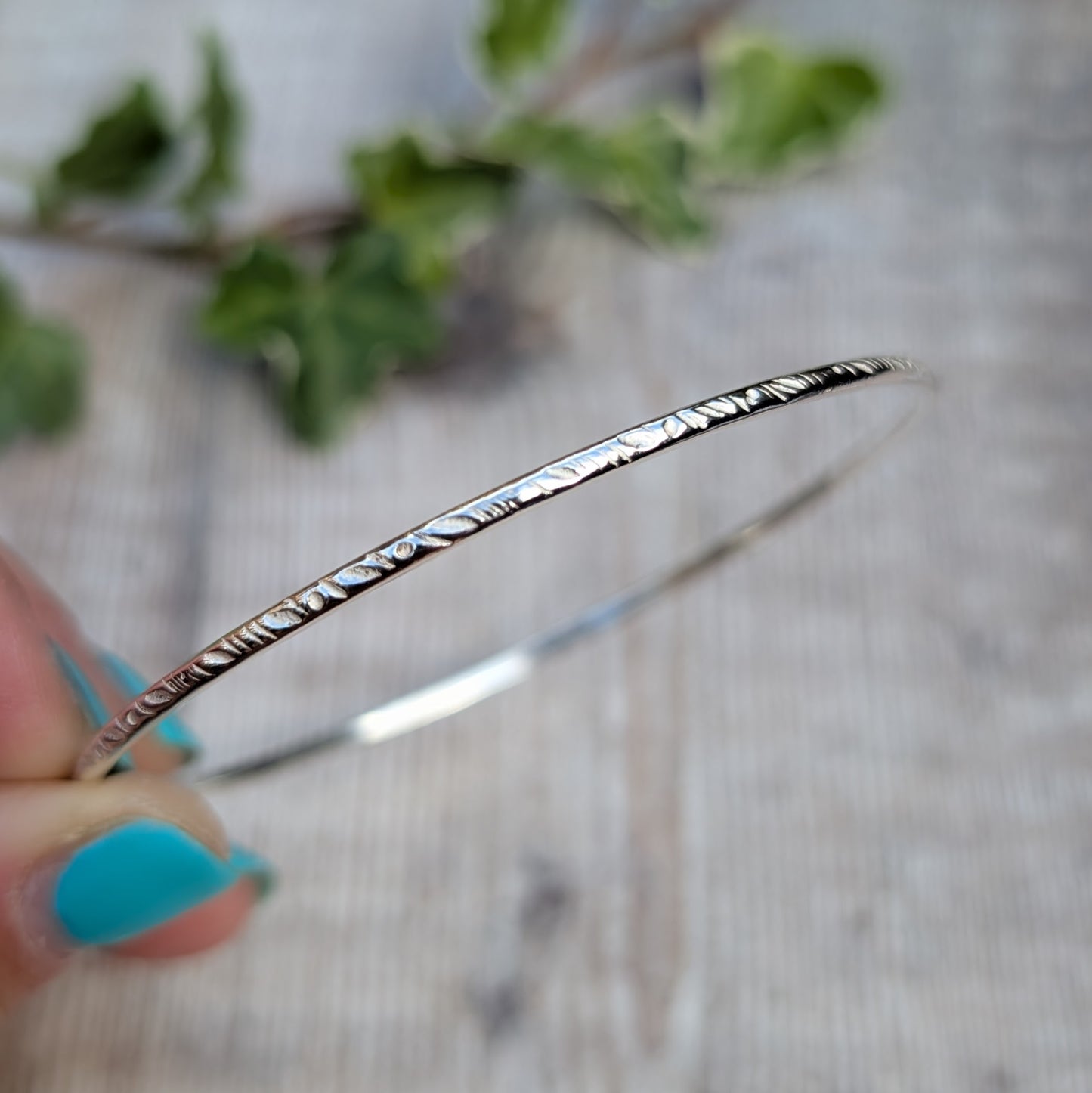 Close up of a Silver Meadow Patterned 2mm Bangle handmade from recycled Sterling Silver 2mm wire with a meadow pattern pressed into the silver using a pattern die.