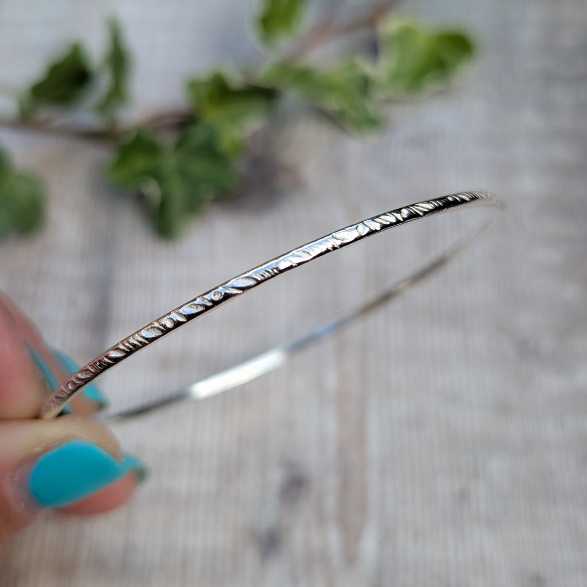 Close up of a Silver Meadow Patterned 2mm Bangle handmade from recycled Sterling Silver 2mm wire with a meadow pattern pressed into the silver using a pattern die.