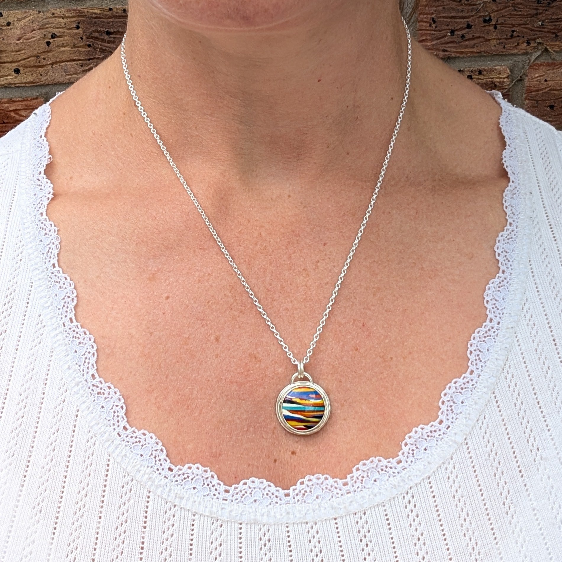 Silver Multicoloured Surfite Round Necklace being worn, showing the size and length of the colourful round Surfite pendant.