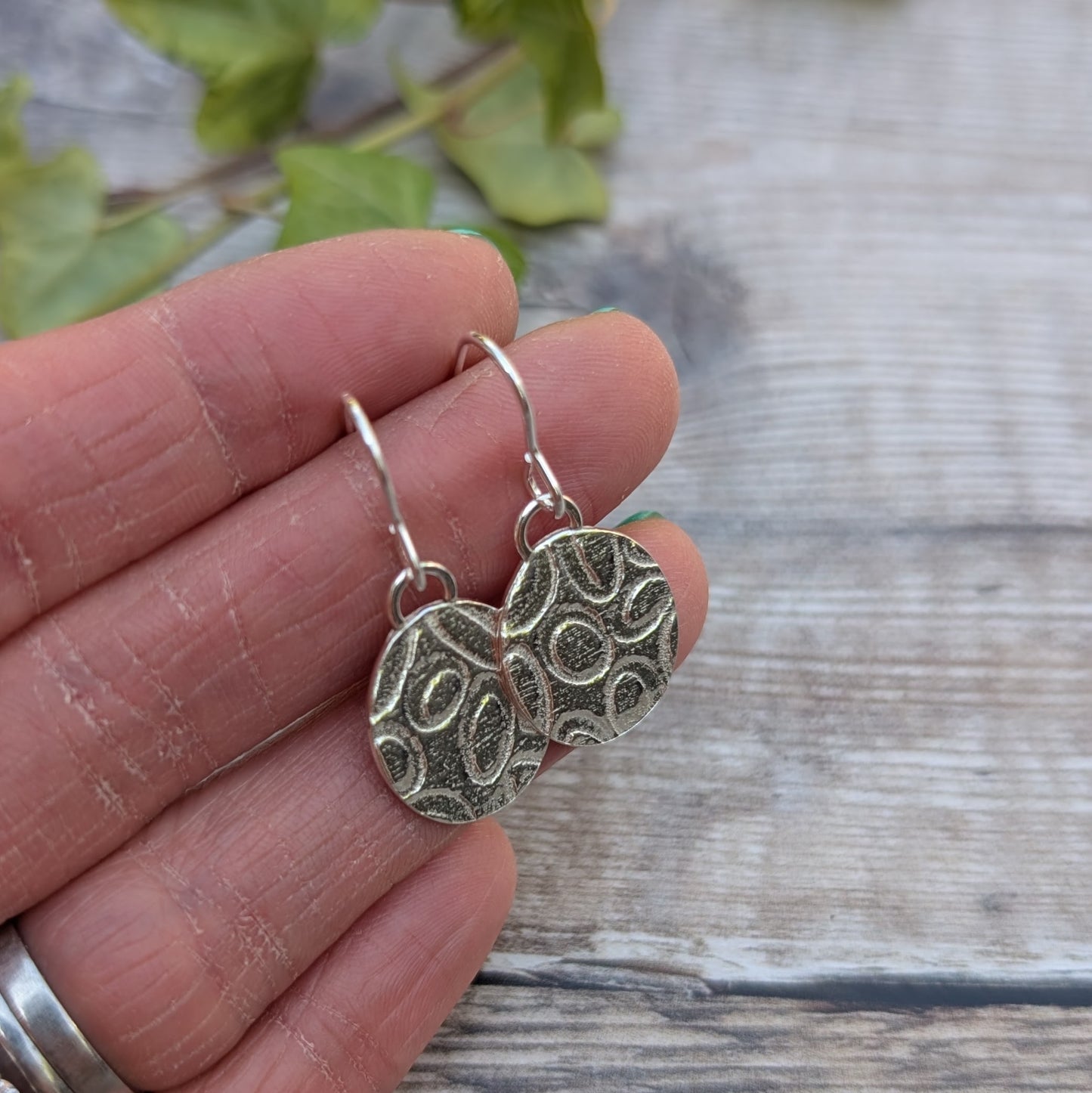 Silver Oval Disc Earrings with Oval Pattern showing detail in the pattern