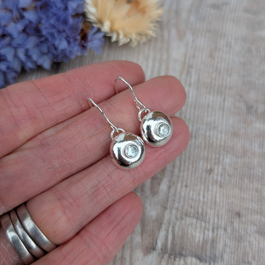 Silver pebble earrings with Aquamarine close up in hand.
