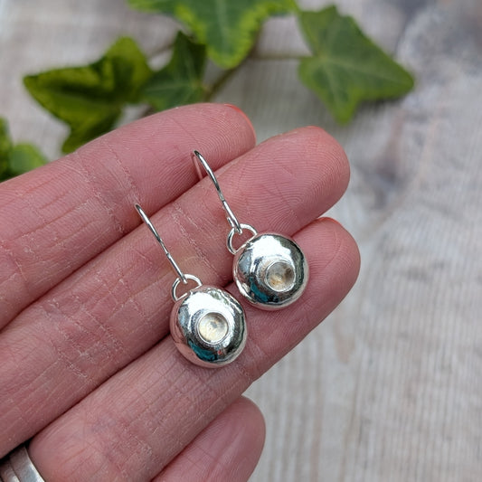 Silver Pebble Earrings with Crystal Quartz held in a hand showing size and detail