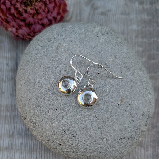 Pair of silver pebble earrings with Labradorite displayed on a smooth grey stone.
