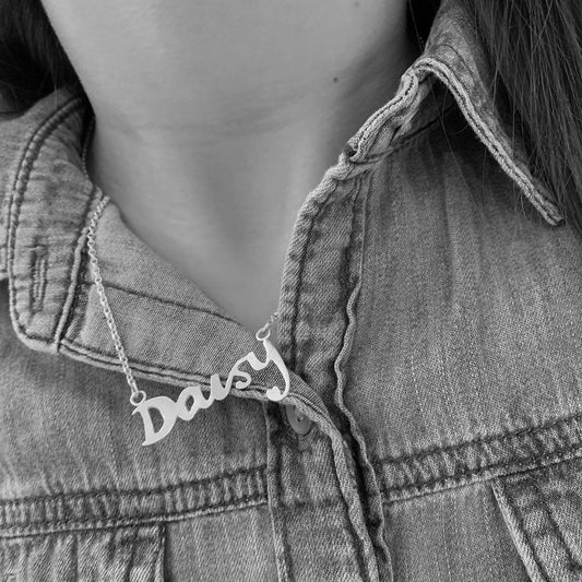 silver personalised name necklace shown being worn. 