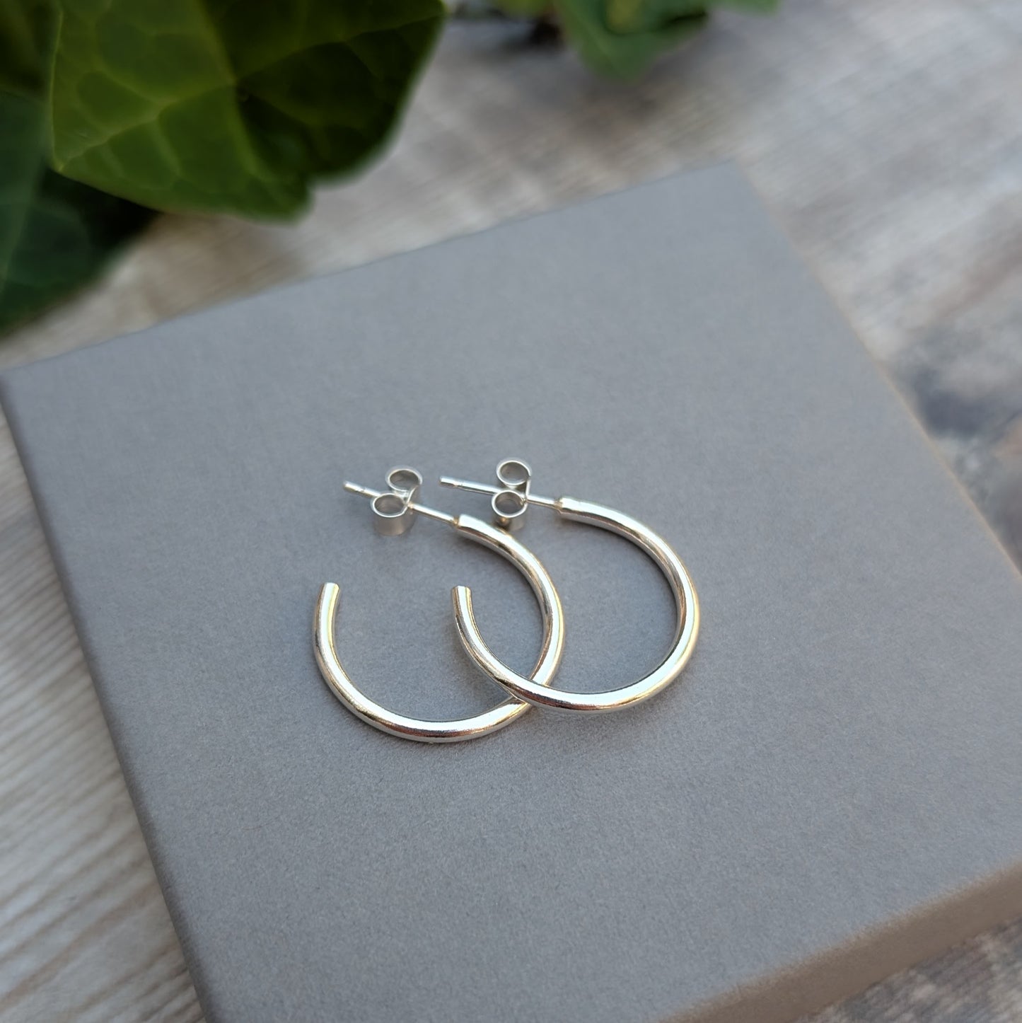 Silver smooth hoop earrings handmade from recycled Sterling Silver displayed on a grey jewellery box, showing the classic polished hoop design.