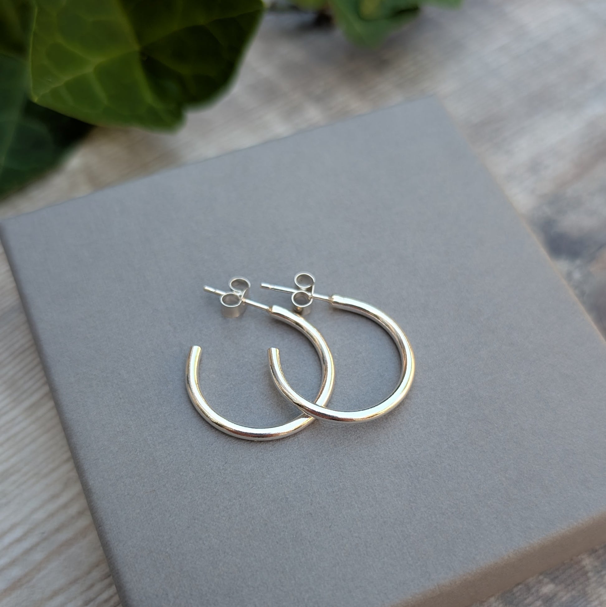Silver smooth hoop earrings handmade from recycled Sterling Silver displayed on a grey jewellery box, showing the classic polished hoop design.