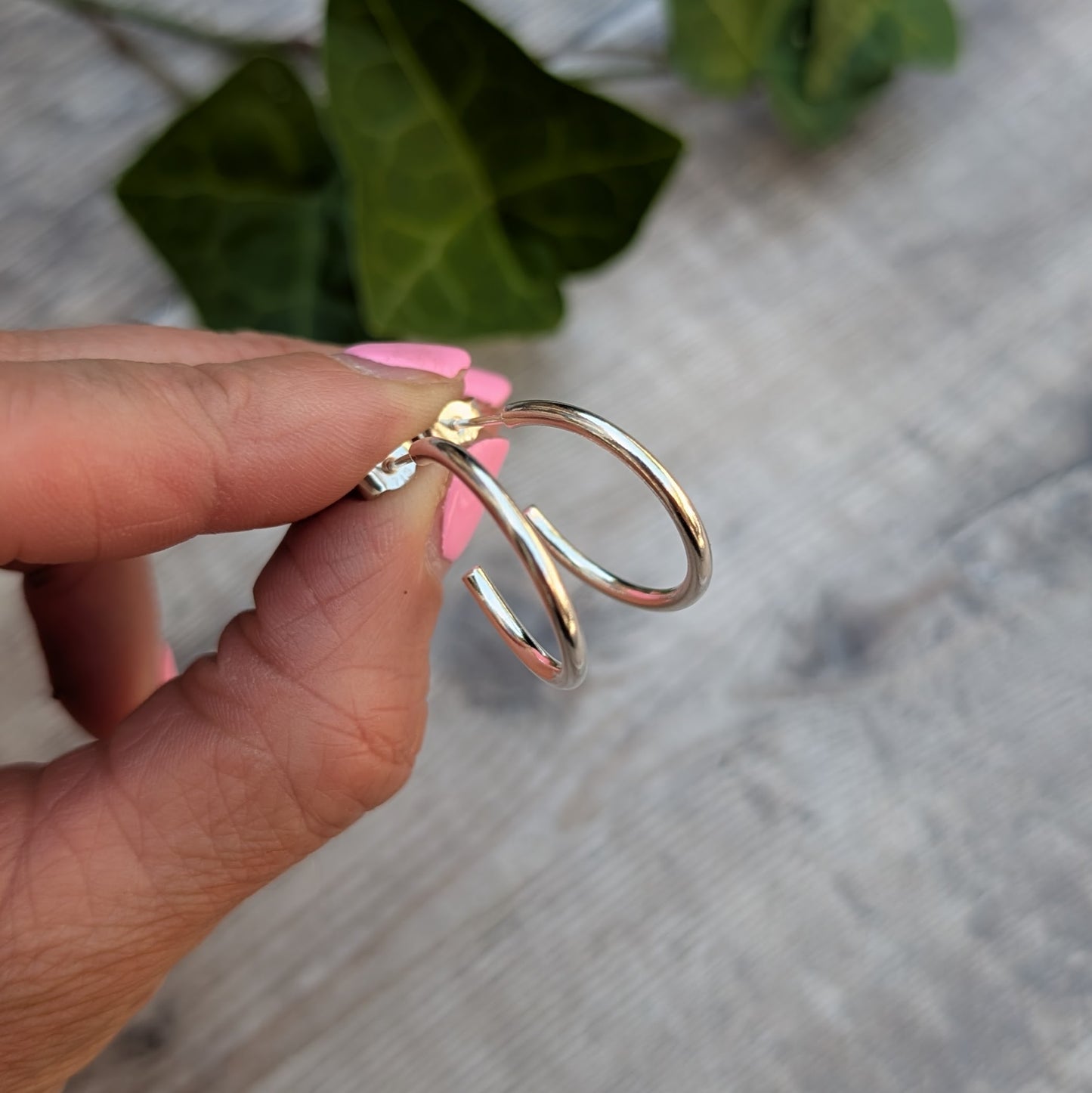 Side view of Silver smooth hoop earrings handmade from recycled Sterling Silver, showing the smooth rounded profile and sterling silver post fitting.