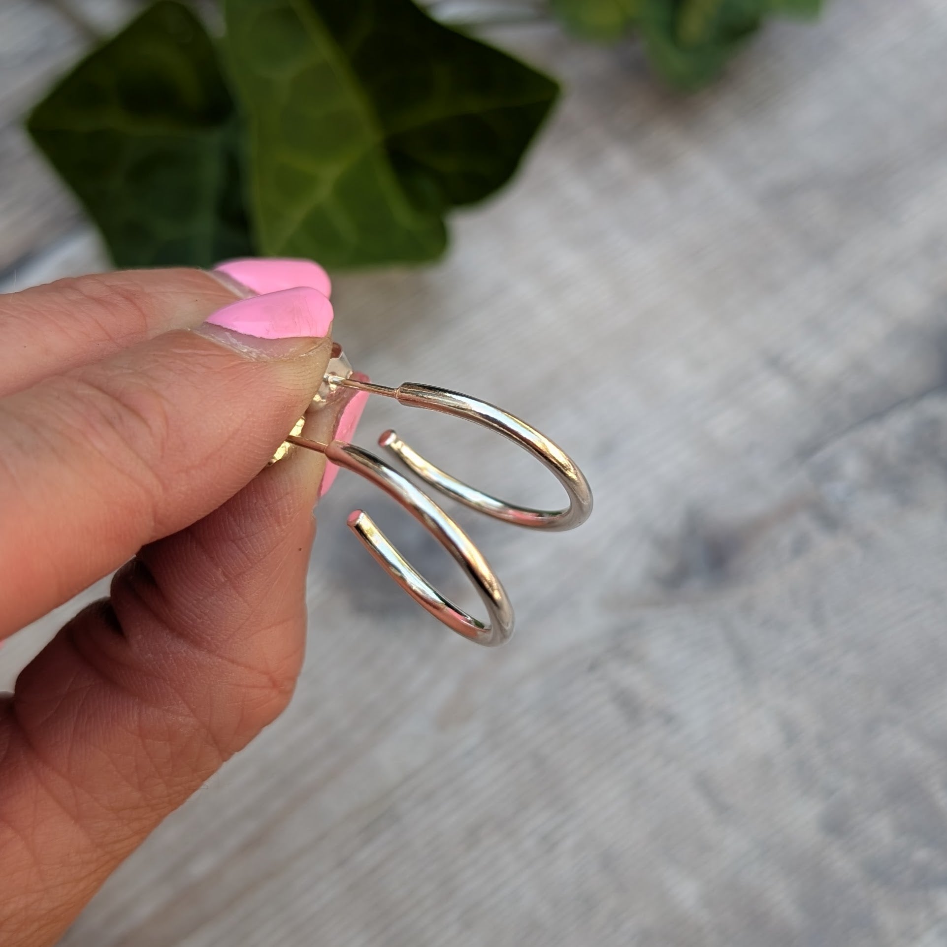 Close up of Silver smooth hoop earrings handmade from recycled Sterling Silver, highlighting the smooth polished finish and post fittings.