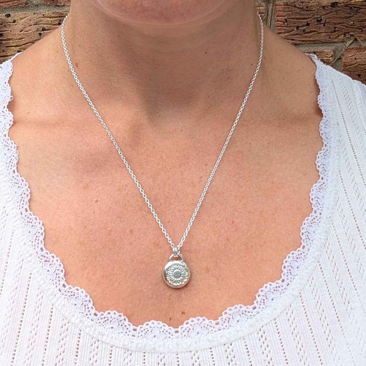 Silver Sunflower Pebble Necklace being worn, showing the size and length of the recycled Sterling Silver sunflower pendant and chain.