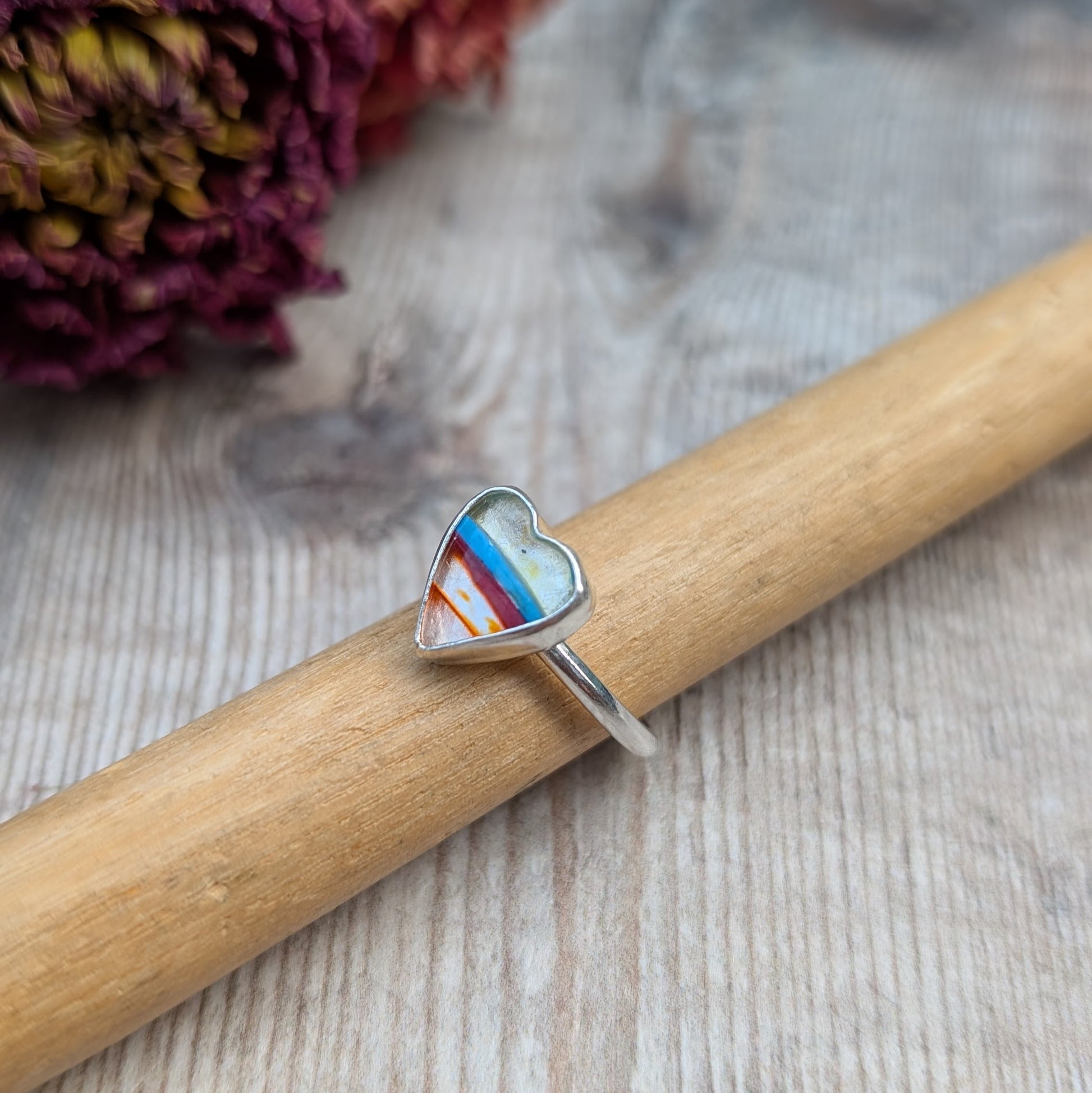 Surfite silver heart ring displayed on a ring mandrel with a wood background.