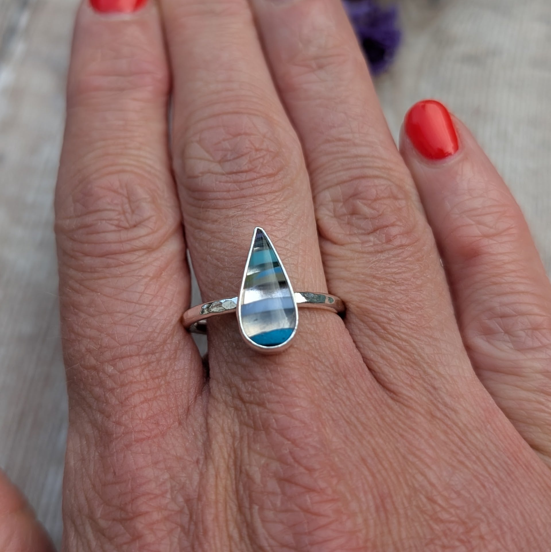 Recycled silver Surfite teardrop ring worn on hand, showing the size and hammered band detail.