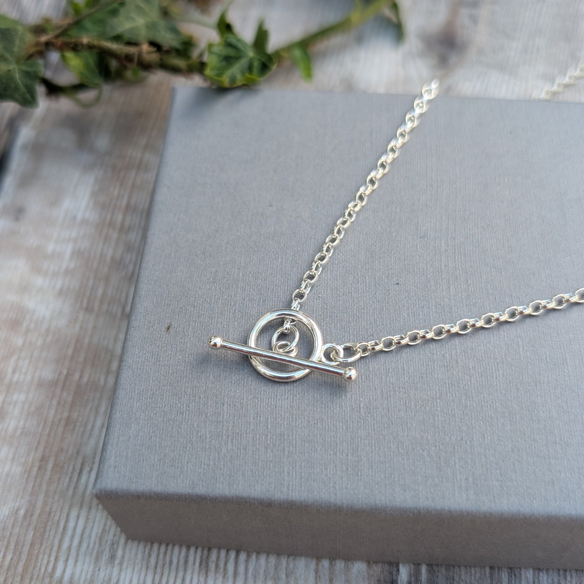 Silver T Bar Necklace handmade from recycled Sterling Silver, shown on a grey jewellery box with a sterling silver chain and T bar clasp detail.