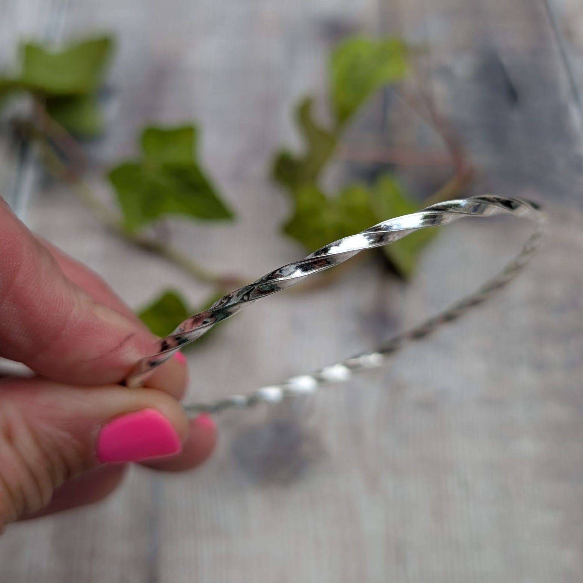 Close up of the Silver Twisted Round Bangle handmade from recycled Sterling Silver 2mm square wire, showing the twisted detail.