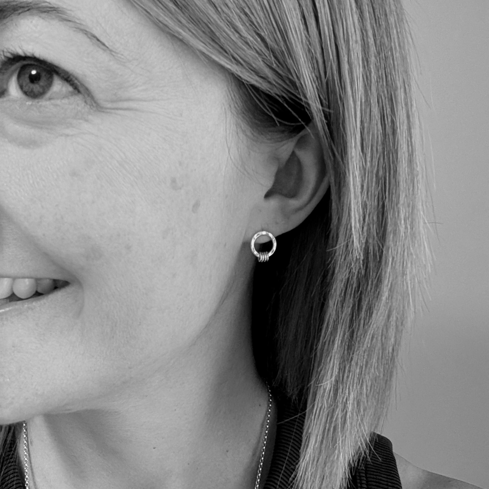 Silver circle stud with gold loops shown being worn. 