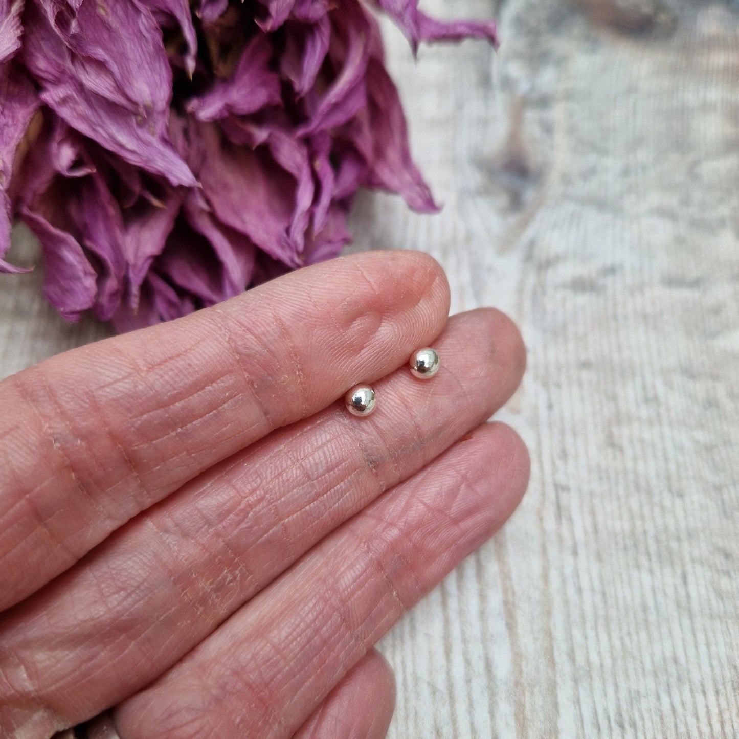 Sterling Silver pebble shape attached to silver earring bar. 