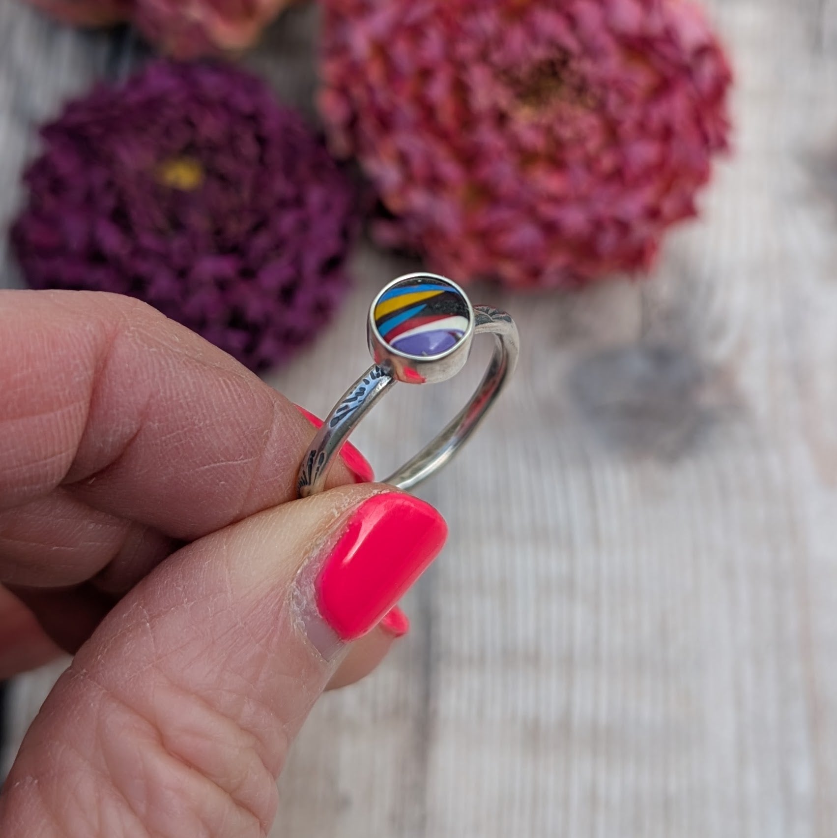 Surfite Ring with Sunburst Stamp close up view showing handmade setting and multicoloured Surfite stone