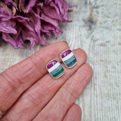 Sterling Silver Surfite Rectangular Stud earrings approximately 8mm x 12mm in diameter each. Each stone is rectangular radiant in shape with rounded edges and flat, shiny surface. The surfite stones are set in silver surrounds mounted on silver stud bars. Colours are cerise pink, white, pale blue, green and turquoise stripes, each earring is individual.