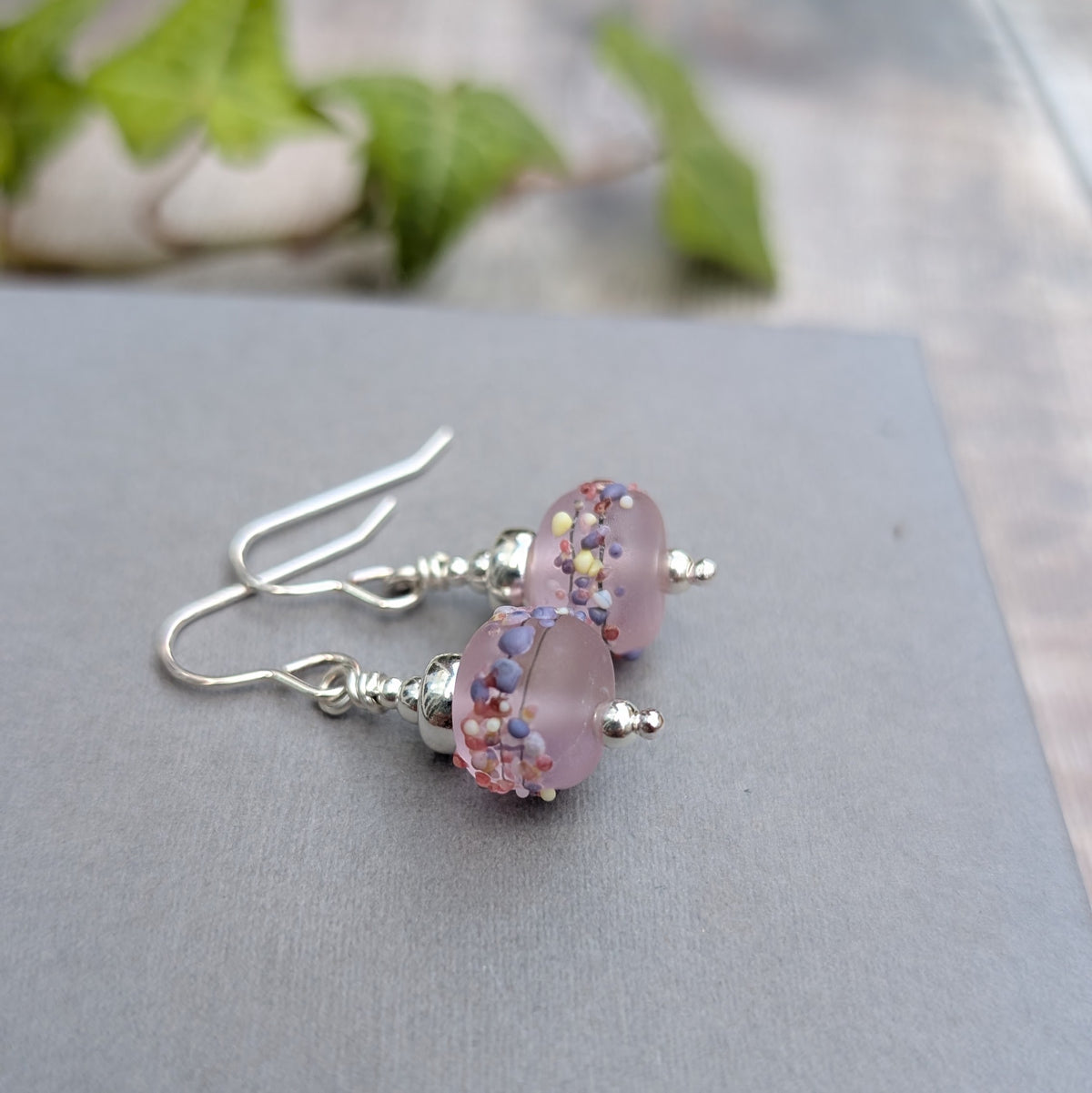 Close up of Tropical Pink Lampwork Glass Earrings showing the frosted pink Lampwork beads with small pink, purple, cream and blue glass details.