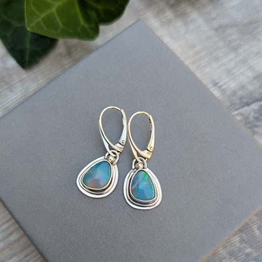 Turquoise Blue Aurora Opal Teardrop Earrings handmade from recycled Sterling Silver, displayed on a grey jewellery box highlighting the vibrant Aurora Opal stones.