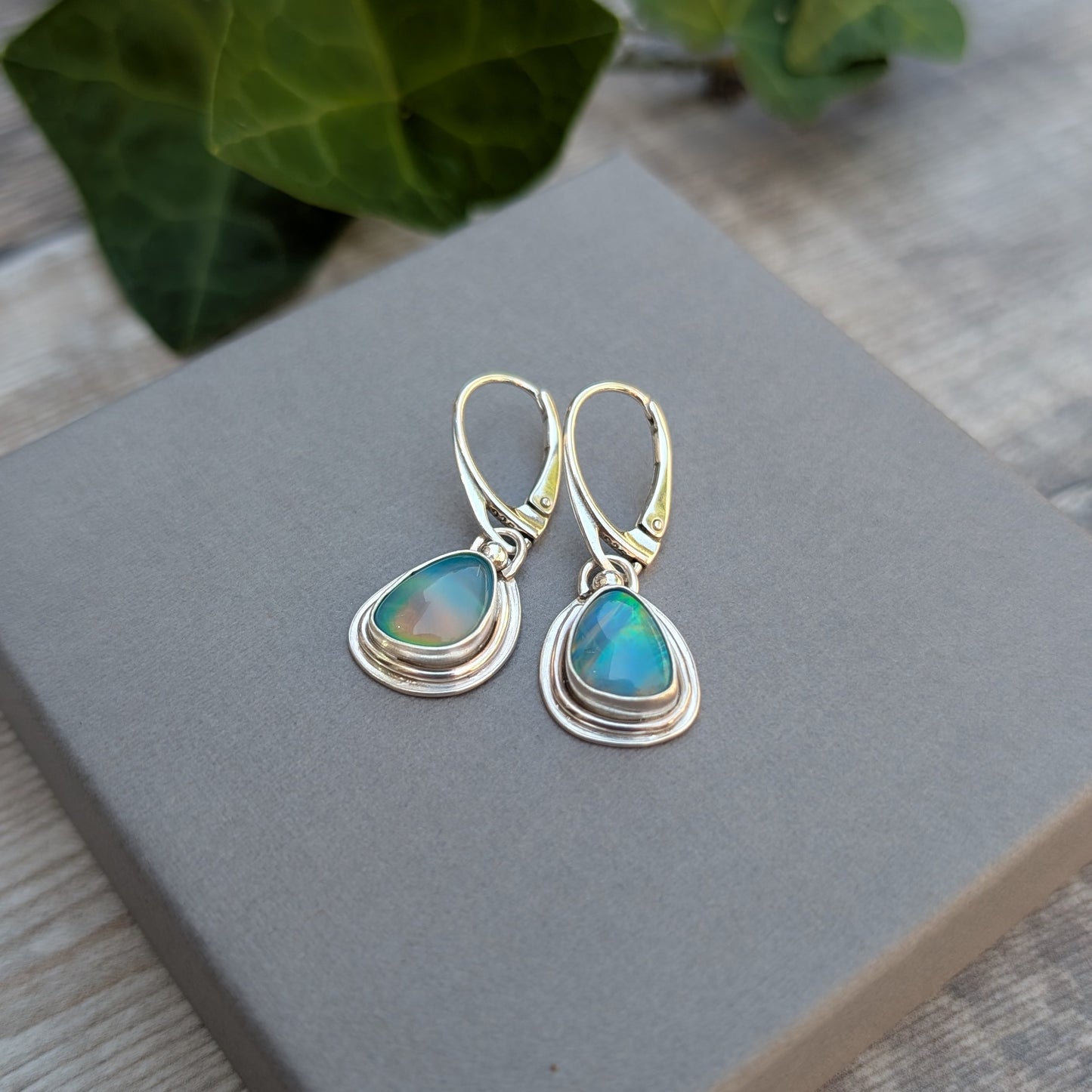 Turquoise Blue Aurora Opal Teardrop Earrings handmade from recycled Sterling Silver, displayed on a grey jewellery box highlighting the vibrant Aurora Opal stones.