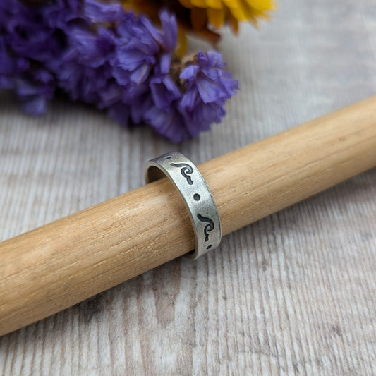 Sterling Silver ring, flat base with simple breaking wave and dot repeating pattern. Oxidisation makes the hand stamped pattern darker and visible.